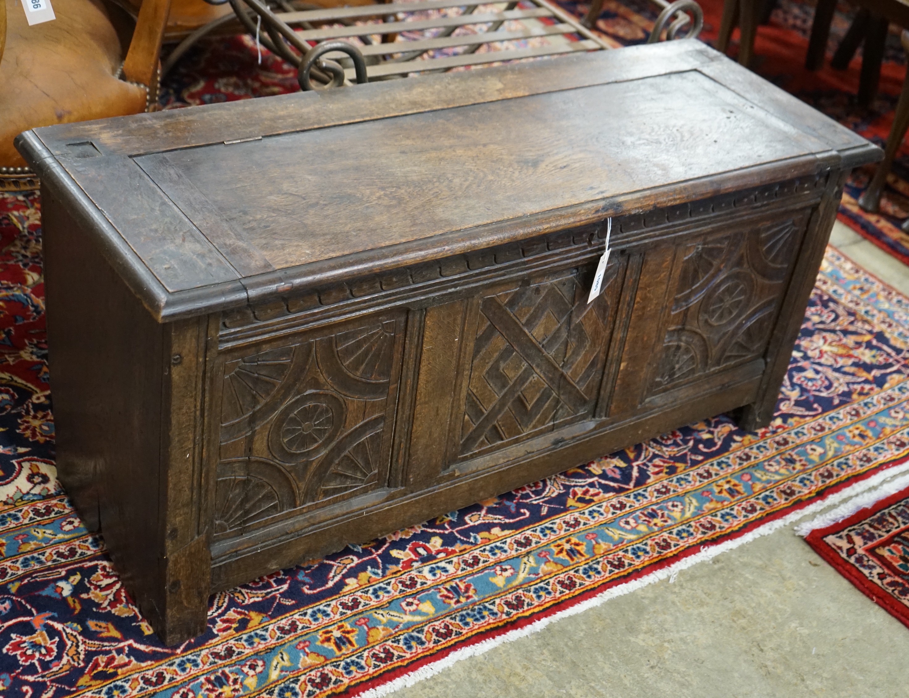 An 18th century style carved oak coffer converted from a monk's bench, width 112cm, depth 41cm, height 52cm